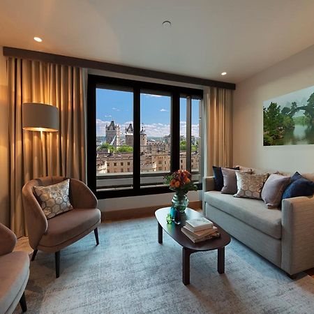 Tower Suites By Blue Orchid London Exteriör bild The photo depicts a modern living room with a contemporary design. It features two stylish, circular chairs and a comfortable sofa adorned with various decorative pillows. A small coffee table is positioned in front of the sofa, topped with books and