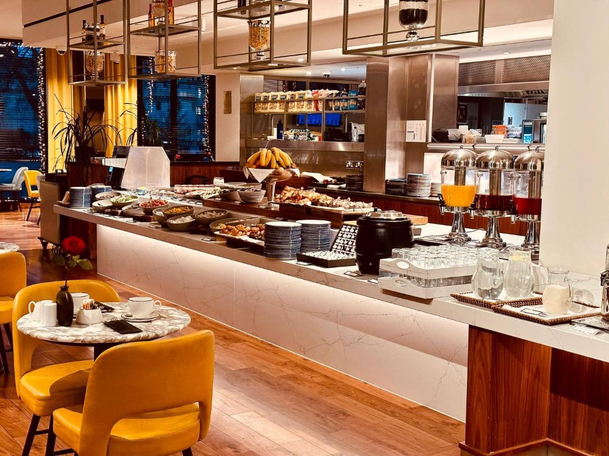 Tower Suites By Blue Orchid London Exteriör bild The photo depicts a modern buffet setting, featuring an array of food items displayed elegantly on a long countertop. There are various dishes, likely including pastries, fruits, and other breakfast items, arranged neatly. In the background, there ar